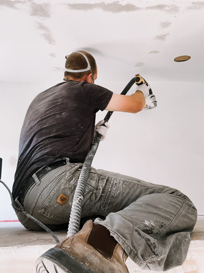 Using paint sprayer to paint playhouse interior