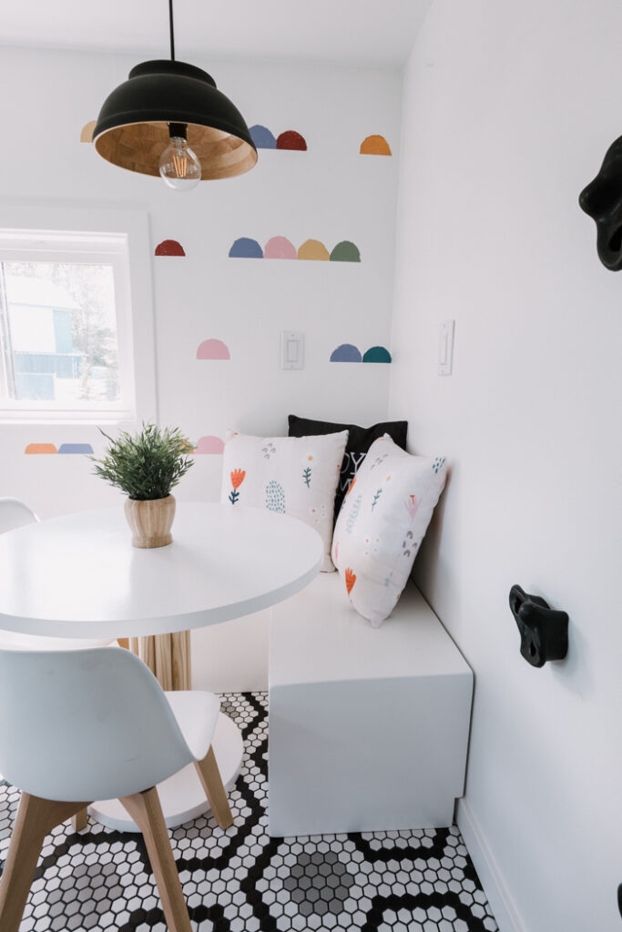 kids dining room with built-in bench, table, and pendant light