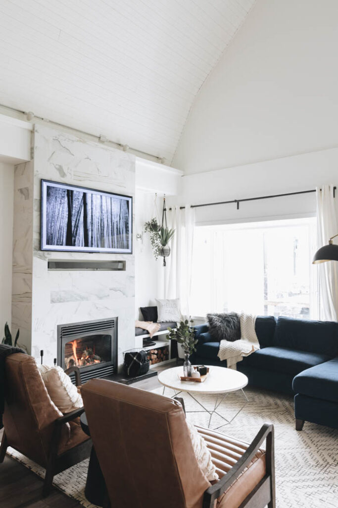 living room with blue couch and brown leather chairs