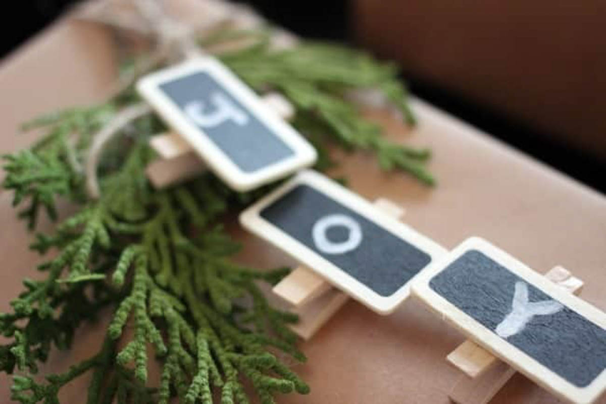 Close up of a joy sign made of clothespins on rustic wrapping paper and greenery