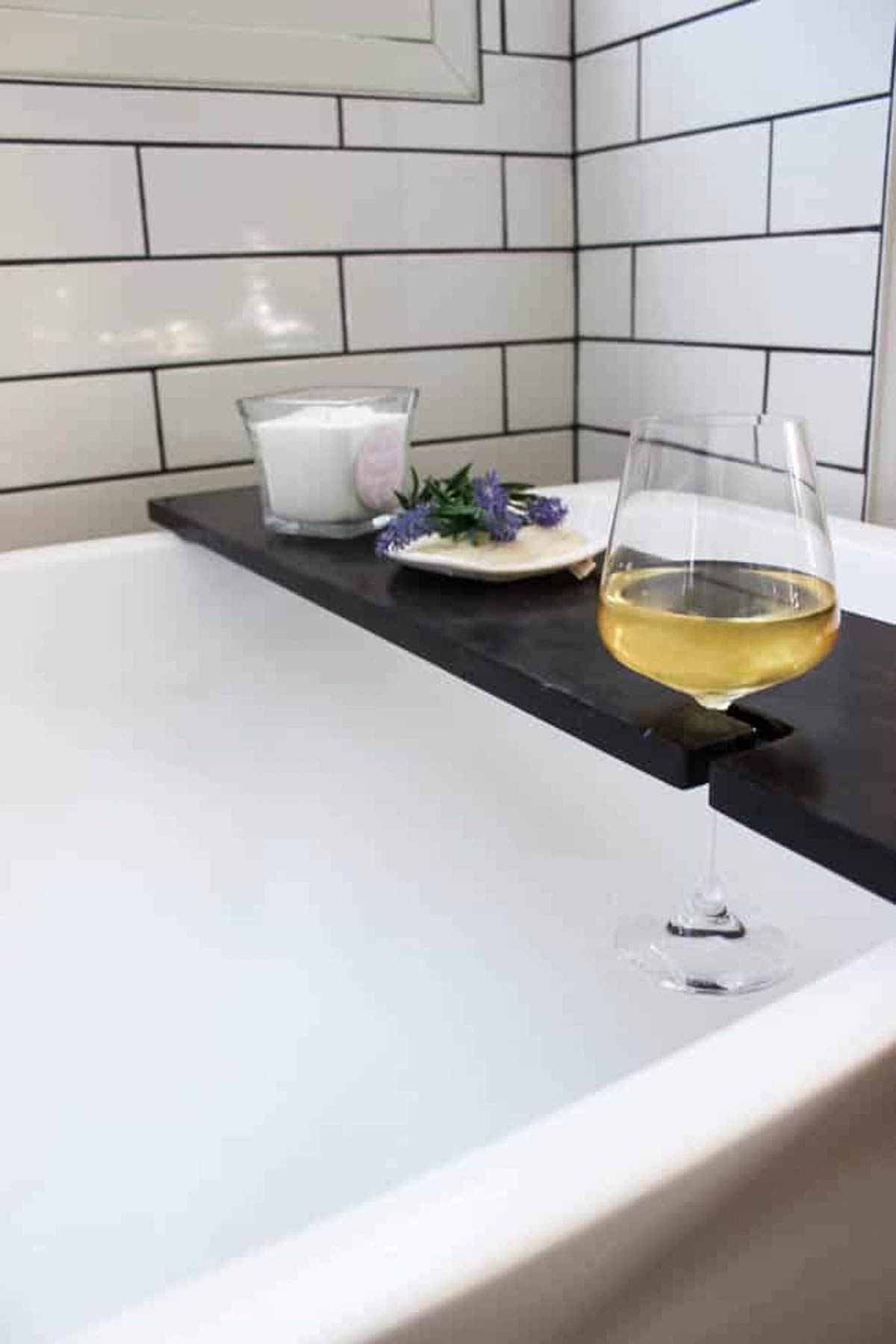 Finished DIY bath tray with wine glass holder on a bath tub