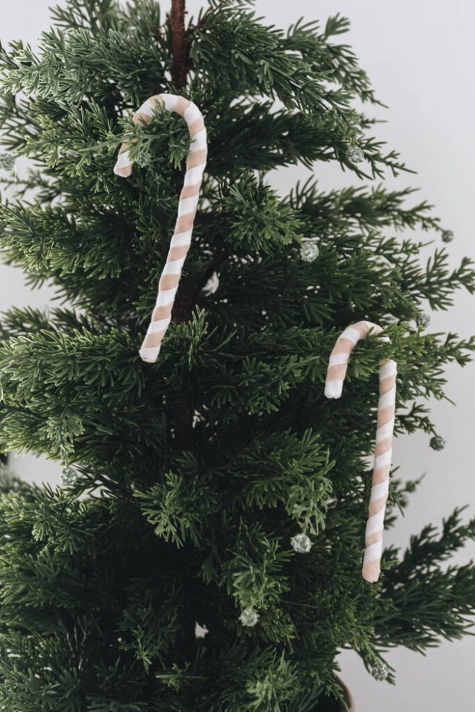 DIY candy cane ornament hanging on faux branch