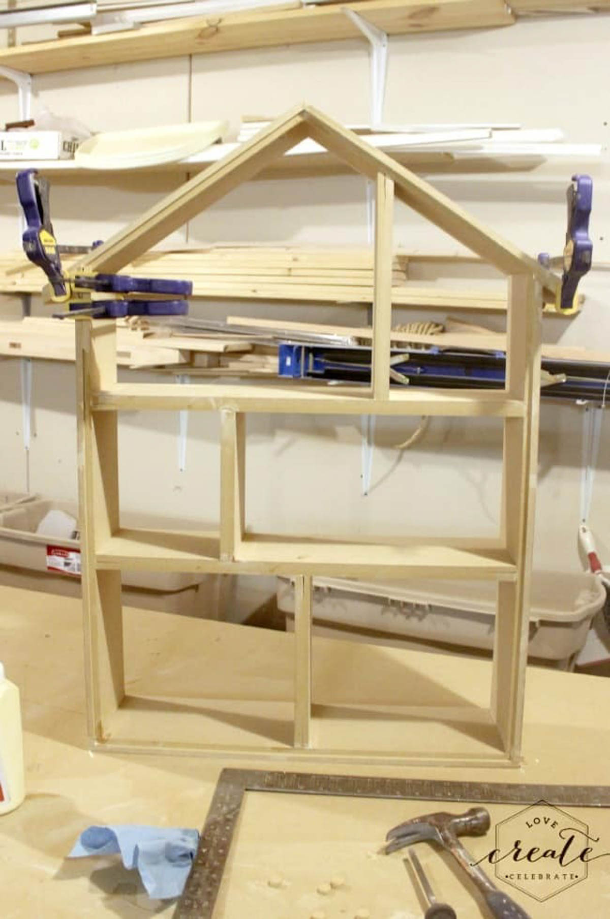 Framed house bookshelf being held together with clamps
