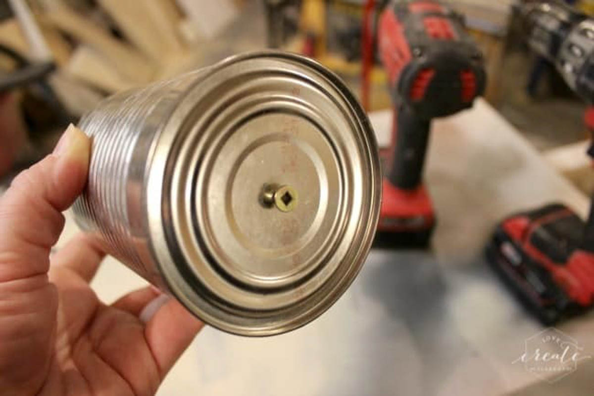 Tin can with screw drilled into the bottom with a drill