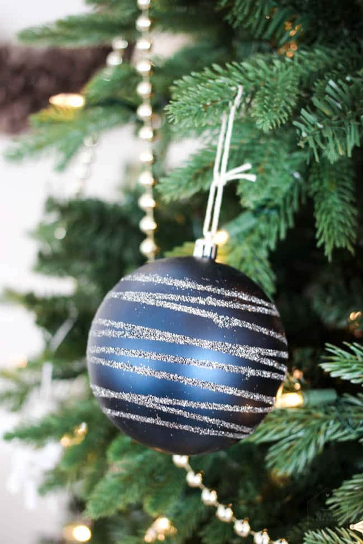 Blue ornament with silver glitter stripes.