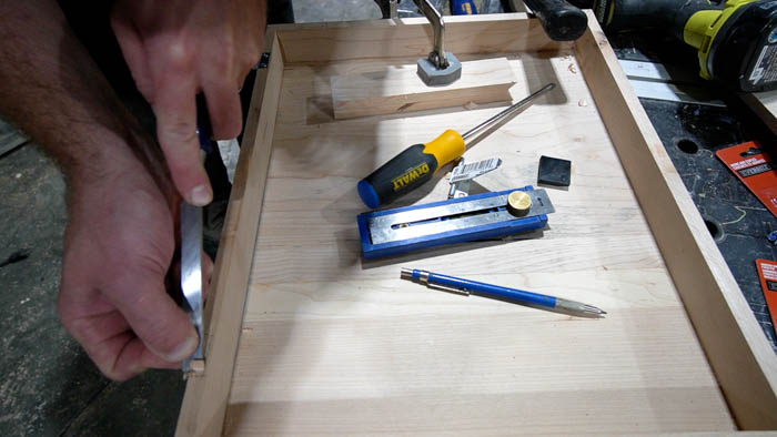 using chisel to cut holes for hinges for using mitre saw to cut boards for DIY Tabletop Easel