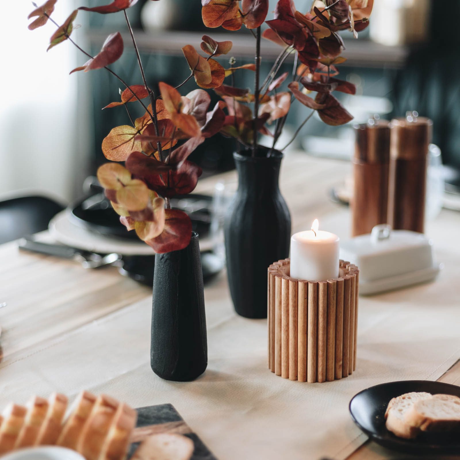 black vases with fall stems on table