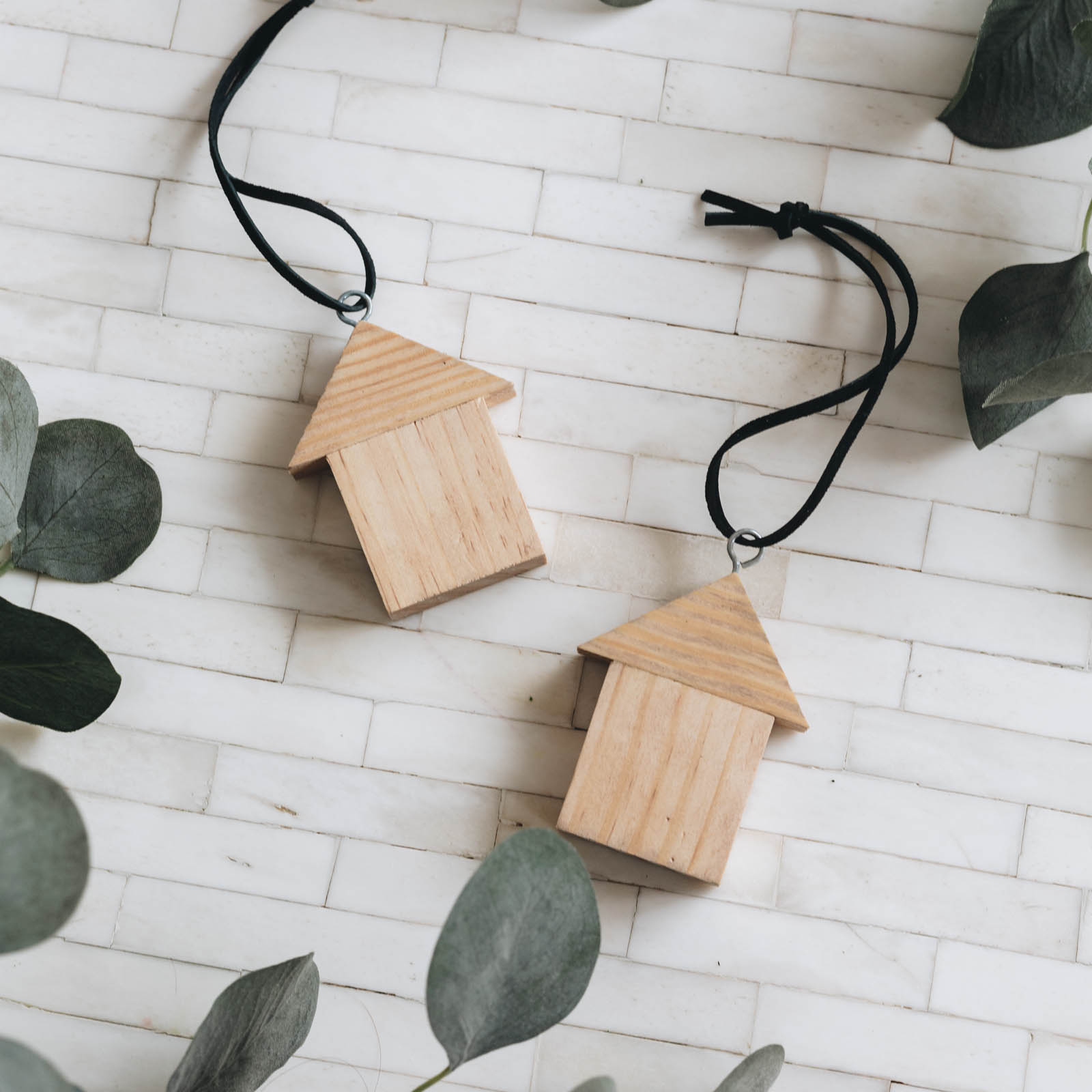 flat lay image or two wooden house ornaments