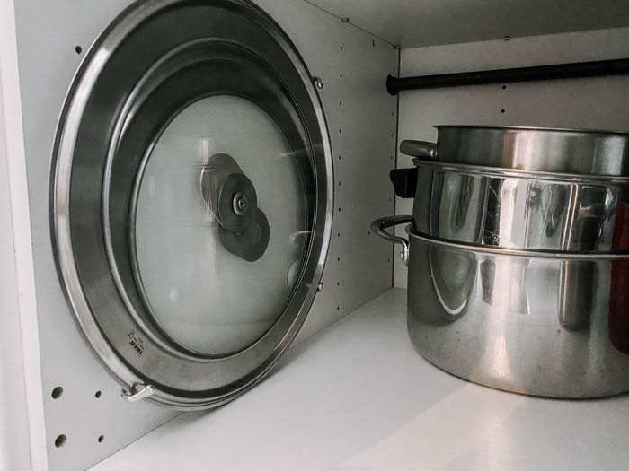 pot lid storage hack in kitchen cupboard