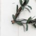 A beautiful non-traditional wreath! Love the look of this triangular modern boho wreath. Such a beautiful DIY project for the autumn season. The addition of leather, feathers, and greenery are perfect for this minimalist wreath. Beautiful greens and browns for wall!